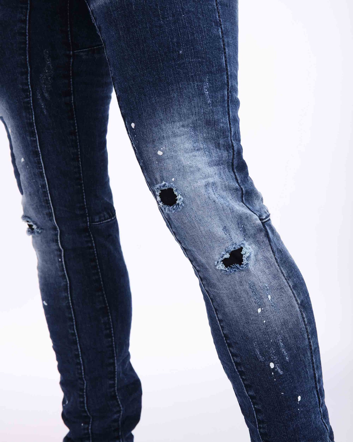 Zerrissene Bluejeans mit Sprühfarbe und rechteckigem Flicken