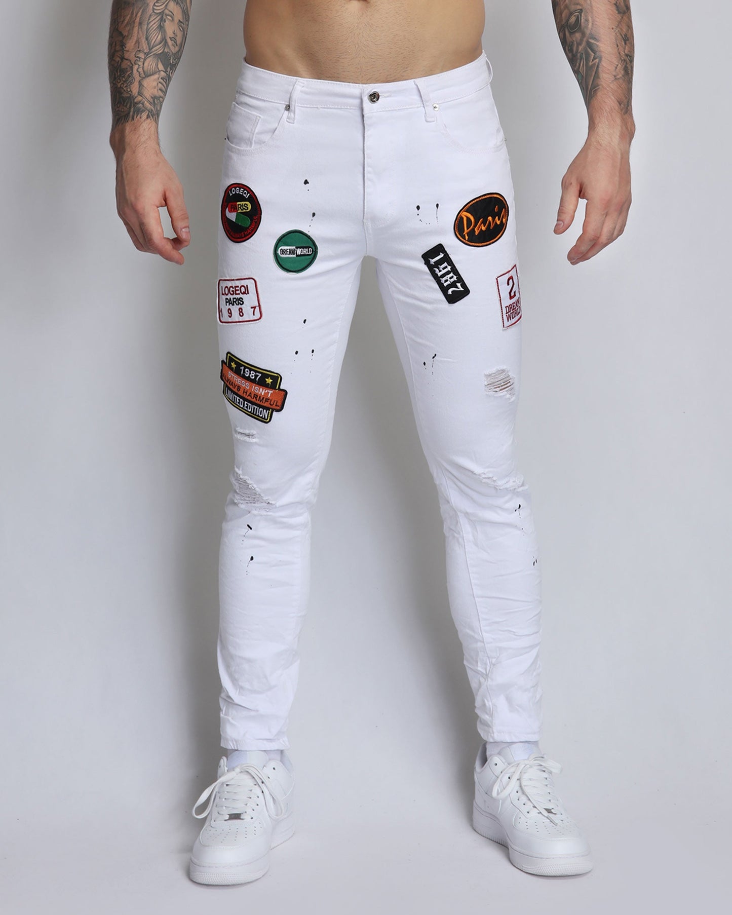 White Ripped Jeans with Badge and Black Spray Paint